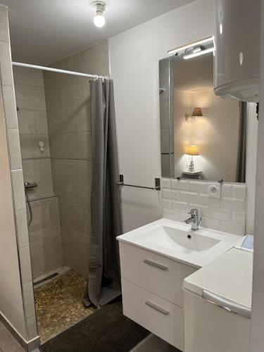 a white bathroom with a shower and a sink at Maureillas - appartement 2 personnes - classé in Maureillas