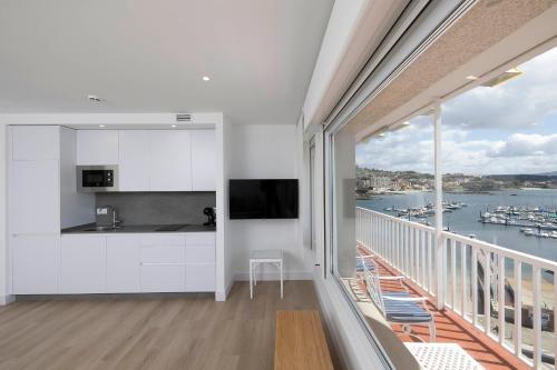 a balcony with a kitchen and a view of the water at Apartamentos Rotilio in Sanxenxo