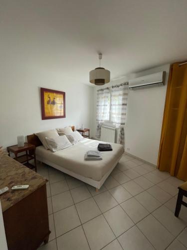 une chambre avec un lit blanc dans une pièce dans l'établissement L’Annexe, à Arles