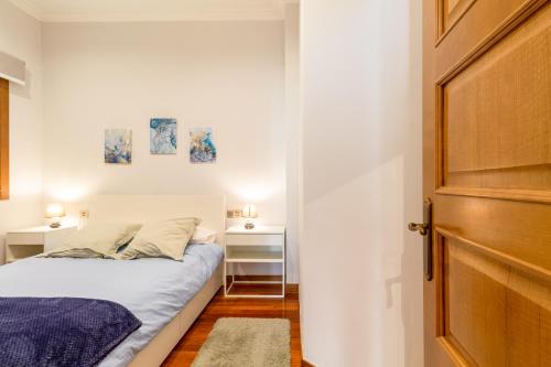 a small bedroom with a bed and a door at Principe Premium Loft Vigo in Vigo