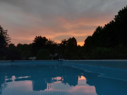 una piscina vuota con un tramonto sullo sfondo di B&B Da Leone a Palazzolo dello Stella