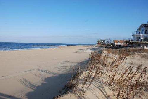 a sandy beach with a house and the ocean at Cozy Suite - Pet friendly, Beach Side apts in Norfolk