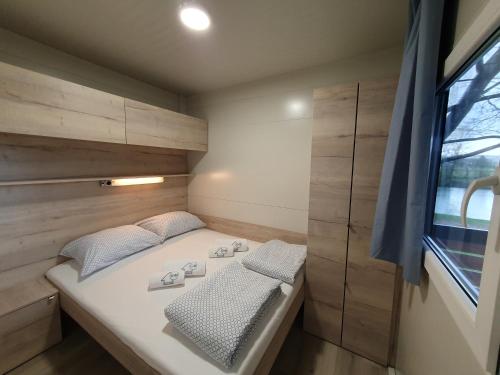 a small bedroom with a bed and a window at GM House, mobile house near Kolpa river in Metlika