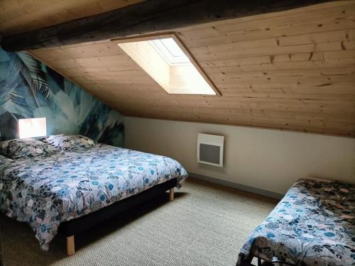 een slaapkamer op zolder met 2 bedden en een dakraam bij La Basse Aubin in Épinal