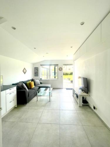 a living room with a couch and a television at HolidayHome Zonnestraal 9p Amsterdam and the beach in Heerhugowaard