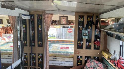 2 x Double Bed Glamping Wagon at Dalby Forest في سكرابورو: غرفة بجدران خشبية وستائر وغرفة بغرفة