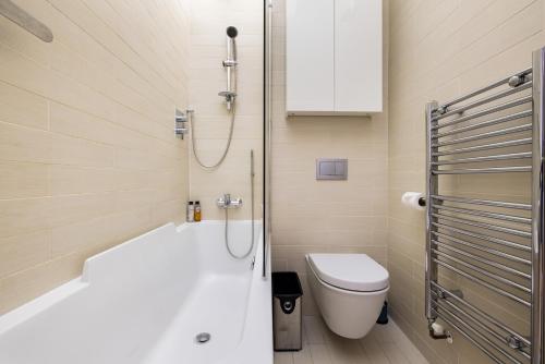 a bathroom with a tub and a toilet and a shower at Stylish & Spacious Notting Hill Loft in London