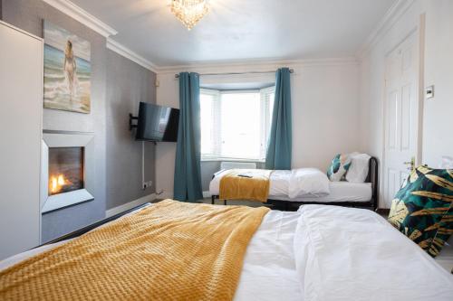 a bedroom with two beds and a fireplace at Renfrew House in Bolton