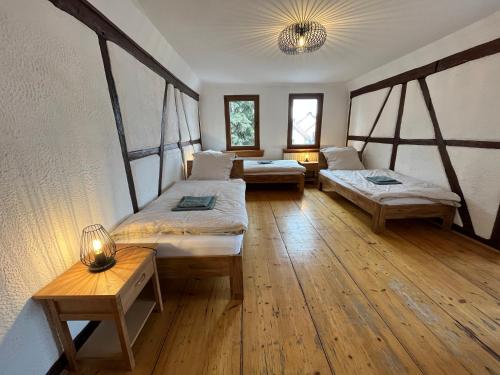 a room with two beds and two tables in it at Ferienwohnungen Am Schloss - Monteurzimmer Reuhl 