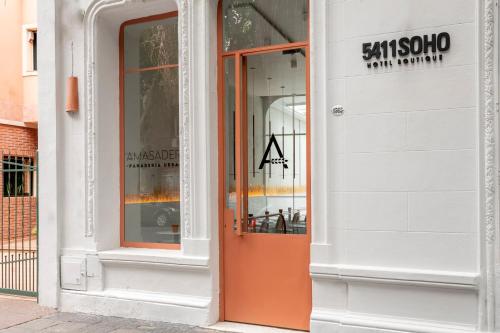an orange door on the side of a building at 5411 Soho Hotel in Buenos Aires