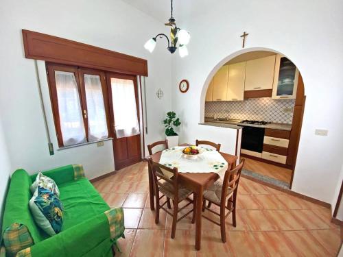 uma sala de estar com uma mesa e um sofá verde em La Casa del Sole em Pantelleria