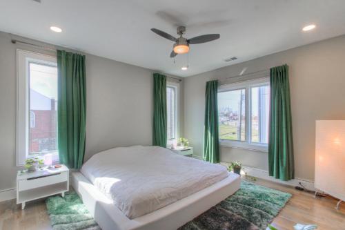 a bedroom with a bed with green curtains and a fan at Luxury 3 Level East-Nash Home w/ Rooftop Terrace in Nashville