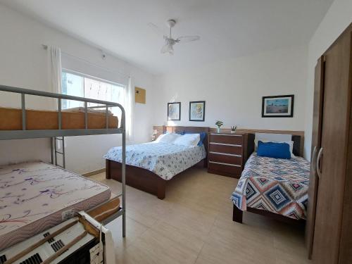 a bedroom with two beds and a bunk bed at Casa de campo Ar piscina Churrasqueira Saquarema in Jaconé