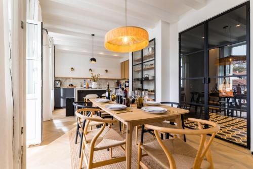 une salle à manger avec une table et des chaises en bois dans l'établissement BLOOM Keyweek Apartment City Center, à Biarritz