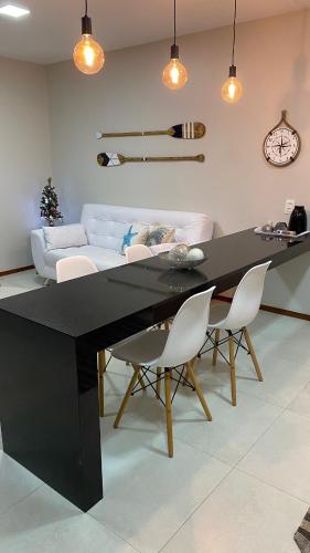 a living room with a black table and chairs at Casa Mar Sonho Verde in Paripueira
