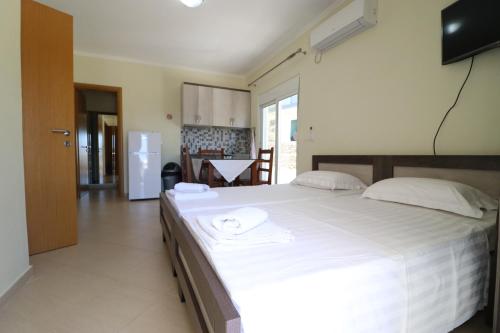 a large white bed in a room with a kitchen at Casa Blanca Rooms in Himare