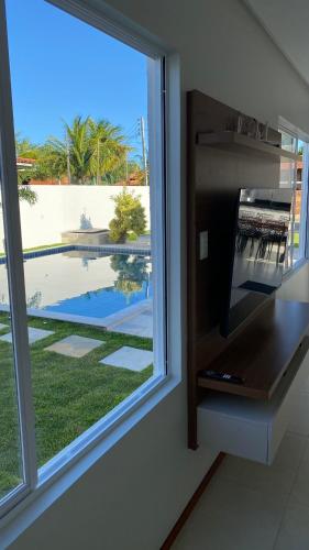 a window in a room with a view of a pool at Casa Mar Sonho Verde in Paripueira