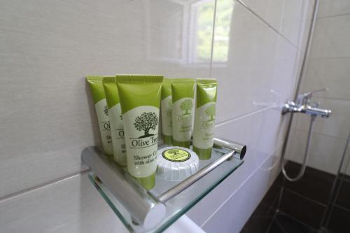 a rack with four bottles of hair products in a bathroom at Casa Blanca Rooms in Himare