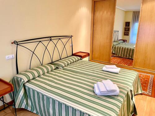 a bedroom with a bed with two towels on it at APARTAMENTO CARMEN in Gijón