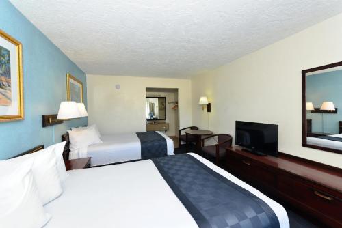 a hotel room with two beds and a flat screen tv at Americas Best Value Inn Bradenton-Sarasota in Bradenton