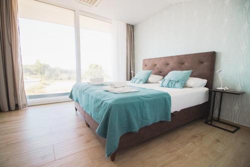 a bedroom with a bed with a blue blanket on it at Villa Cornea - Luxury Villa in a heart of Novalja in Novalja