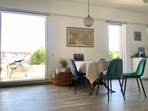 米蘭的住宿－Appartamento con terrazza in zona Navigli - Tortona，一间带桌子和绿色椅子的用餐室