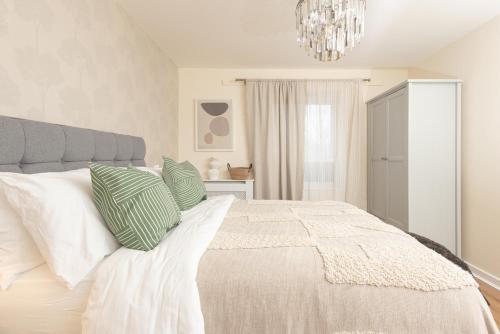 a bedroom with a bed with green and white pillows at Luxury Apartment, Birmingham-Parking in Birmingham