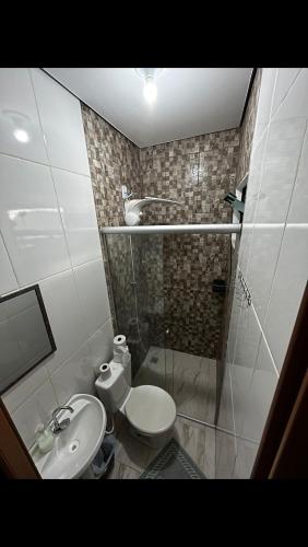 a bathroom with a shower and a toilet and a sink at Pousada Valle das Aguas in Maria da Fé