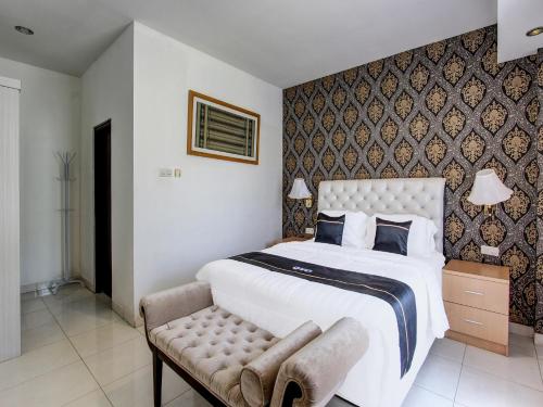 een slaapkamer met een groot wit bed en een stoel bij Super OYO Collection O 92254 Hotel By Orchid in Duwet