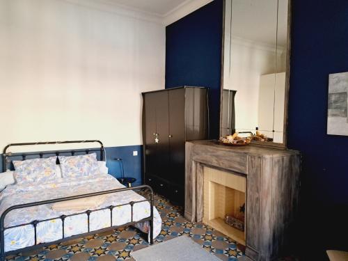 une chambre avec un lit et une cheminée dans l'établissement Le Jaurès, à Narbonne
