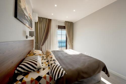 a bedroom with a bed and two pillows at Sunbreeze Delux Vilas in Budva