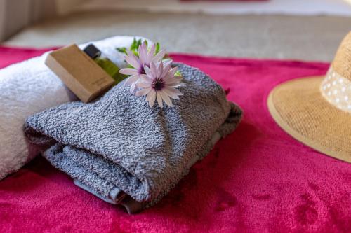 a towel with a flower on it next to a hat at The Morus House with Private pool in Melidhónion