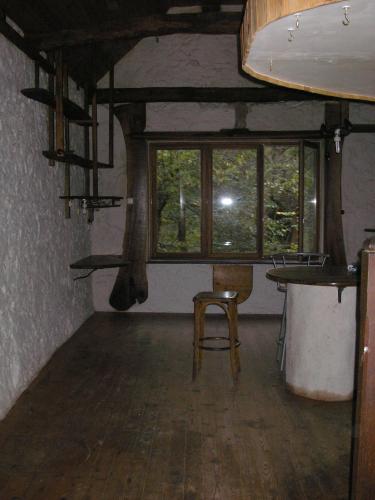 a room with a chair and a table and windows at grange rénovée en pleine nature in Valady