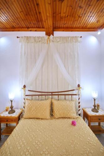 a bedroom with a large bed with two lamps on tables at Vasia's Small Villa in Skopelos Town