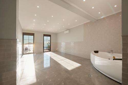 a large bathroom with a tub and a large room at Sunbreeze Delux Vilas in Budva