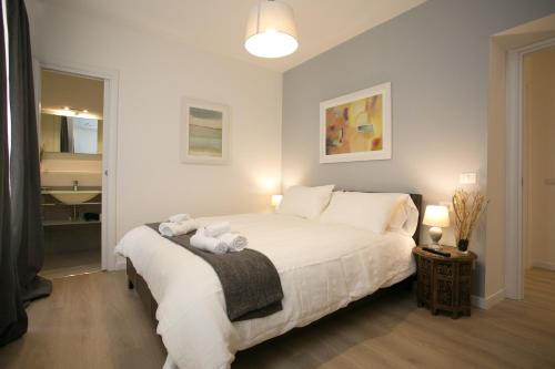 a bedroom with a white bed with towels on it at Thebestinrome Piazza del Popolo - Vico in Rome