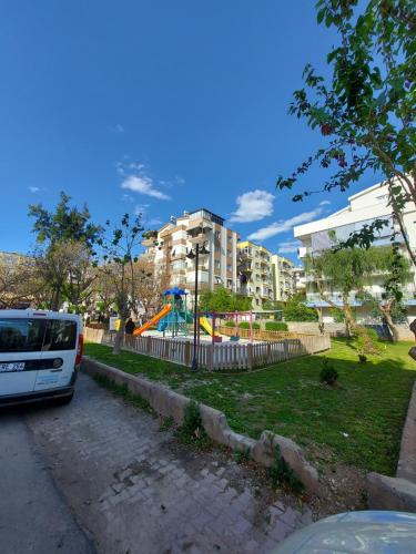 a white bus parked in a park with a playground at MY Garden View in Antalya