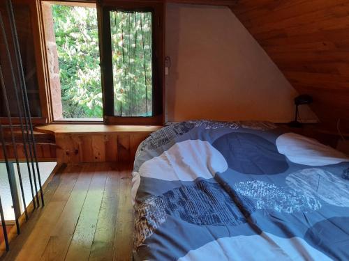 Bett in einem Zimmer mit 2 Fenstern in der Unterkunft grange rénovée en pleine nature in Valady