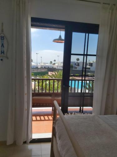 a bedroom with a bed and a view of a balcony at Casa Tortuga in Costa Teguise