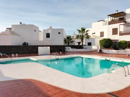 a swimming pool in front of a villa at Casa Tortuga in Costa Teguise