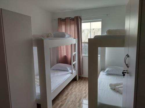 a room with two bunk beds and a window at RESIDENCIAL BOTÂNICO in Curitiba