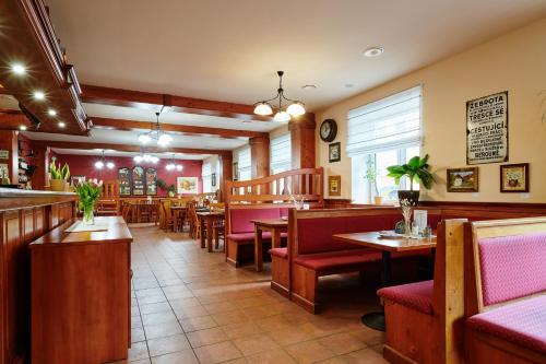 a restaurant with tables and chairs and a bar at Hotel Terasa in Vimperk