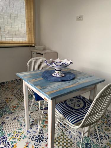 a table with two chairs and a bowl on it at La Baia di Napoli in Capri