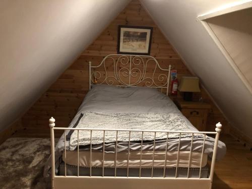 een slaapkamer met een bed op zolder bij Sweet Meadow A delightful romantic thatched cottage by river Shannon on 4 acres is for peace party family or work from home in Rooskey