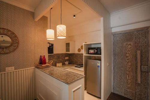 a kitchen with a counter and a refrigerator at Aloha Ganga view 2BHK Apartment by Almost Heaven in Rishīkesh
