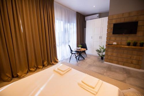 Habitación de hotel con cama, TV y mesa. en Casa Doner Rooms en Craiova