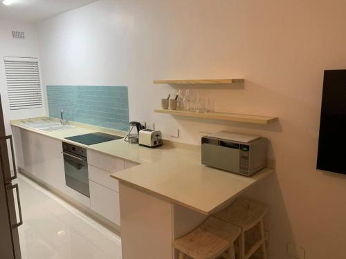a kitchen with a counter with a sink and a microwave at Sea Breeze Studio in Umdloti