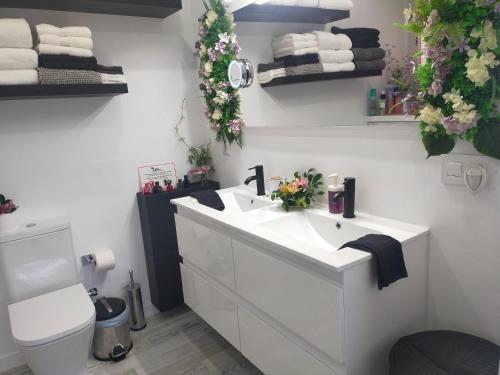 een badkamer met een wastafel, een toilet en handdoeken bij Playa Monis 2 in Icod de los Vinos
