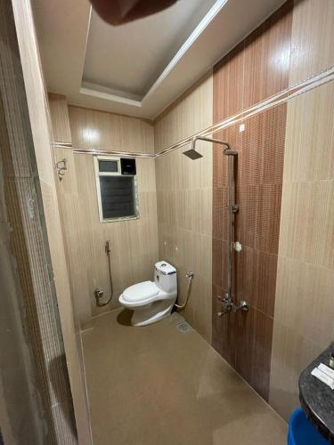 a small bathroom with a toilet and a shower at Hotel Gulmohar in Parbhani