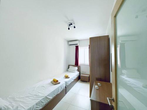 a small room with two beds and a mirror at Modern St.Julian's Heart 2 Bed 2 Bath | Paceville in St. Julianʼs